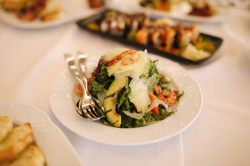 Fresh salad in restaurant on the table. Banquet concapt. Different salads with tomato, arugula, chicken, avocado, parmesan, shrimp