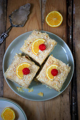 Homemade cake Napoleon with raspberry and orange, puff pastry custard cream pie on wooden table, rustic style top view
