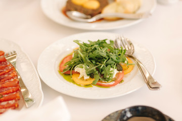 Fresh salad in restaurant on the table. Banquet concapt. Different salads with tomato, arugula, chicken, avocado, parmesan, shrimp