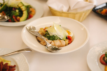 Fresh salad in restaurant on the table. Banquet concapt. Different salads with tomato, arugula, chicken, avocado, parmesan, shrimp