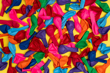 Mix of colored balloons on yellow background