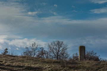 Fototapeta na wymiar skulptur aus stein in der natur mit wolken am blauen himmel