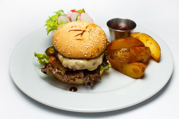 burger with pork and vegetables, salad, french fries, cheese sauce