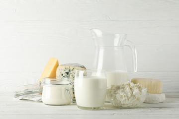 Different dairy products on white wooden background, copy space