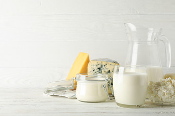 Different dairy products on white wooden background, copy space