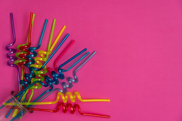 Red, blue and yellow straws on a pastel background