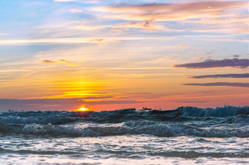 Sunset over the sea. Reflection of sunlight in the sea waves. The sky in the sunset rays.