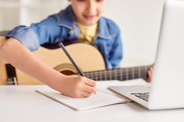 Girl making notes during guitar lesson
