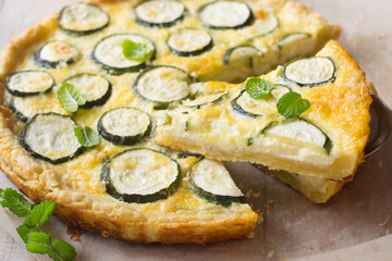 Zucchini tart on wooden table. Shortcrust pastry. Cream, egg, cheese fill