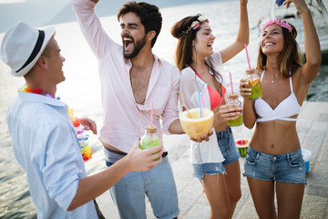 Group of friends having fun and dancing on the beach. Summer party on the beach