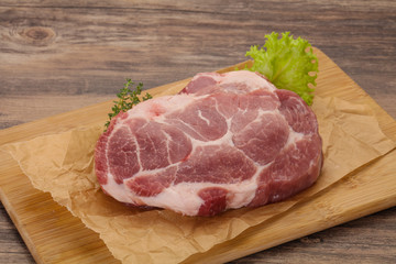 Raw pork steak over wooden board