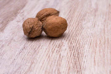 Whole walnuts on cream colored wood, healthy food