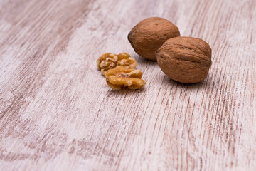 Whole walnuts on cream colored wood, healthy food