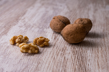 Whole walnuts on cream colored wood, healthy food