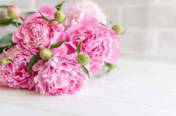 Pink peony flowers on white wooden table. womans day or wedding background.