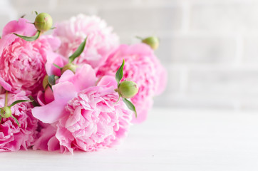 Pink peony flowers on white wooden table. womans day or wedding background.