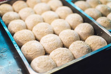 Sheng Jian Bao: White pork bun topping with sesame before fry. Street food of Jiantan in Taipei, Taiwan.