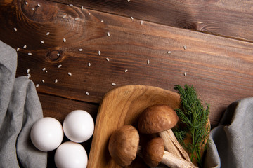 wooden tray with porcini mushrooms on a wooden table. Ingredients before cooking. Copy space