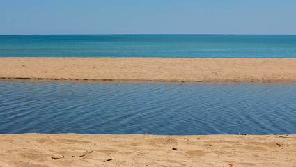 Harmony of nature - sand, river, sea, and sky. At the mouth of the Kamchia River in August. Black Sea, Bulgaria.