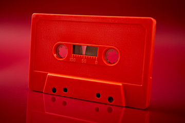 Obraz premium orange audio cassette on the dark red background