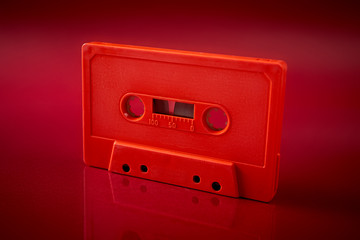 orange audio cassette on the dark red background