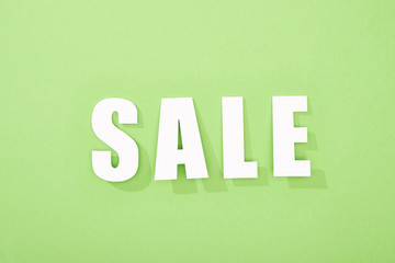 top view of white sale lettering on green background