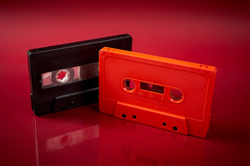 Obraz premium orange and black audio cassette on dark red background