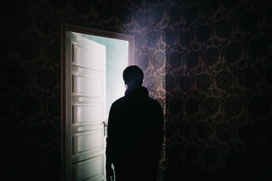 Man against bright light in opened door