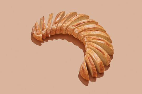 Sliced white bread, homemade in the form of semicircle on a pastel beige background with copy space.