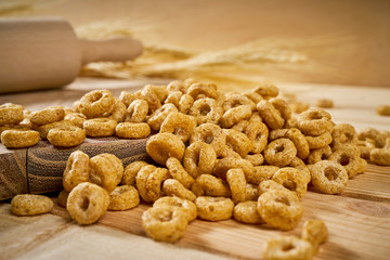 crunchy breakfast on a wooden table with ears of rye and rolling pin