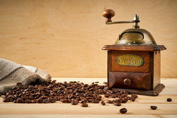 old coffee grinder on a wooden table with seeds