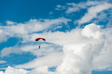 Man on a parachute in a blue sky with clouds