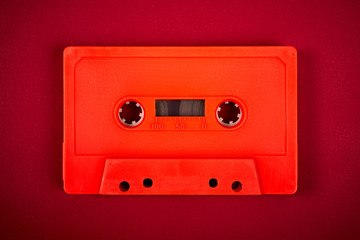 Obraz premium orange audio cassette on the dark red background