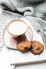 Beautiful enameled pink cup of coffee with blanket and laptop