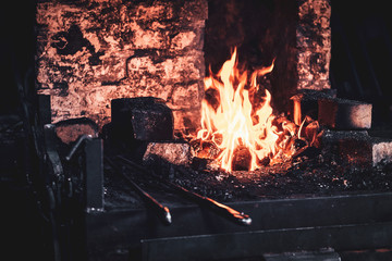 Fototapeta premium Stove with fire at blacksmith workshop. There are different tools around.