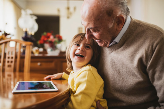 3 year old boy with his grandfather using a digital tablet