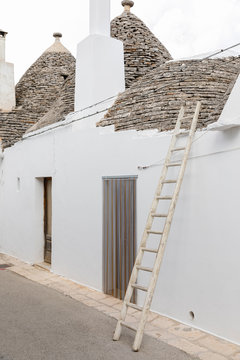 Ladder leaning against a trullo, typical building in the village of Alberobello