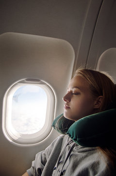 Young lady sleeping near plane window