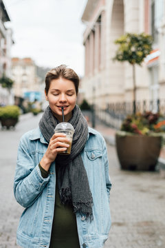 Young lady enjoying?drink on street