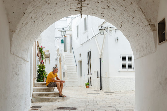 Man sitting on the steps in a characteristic alley