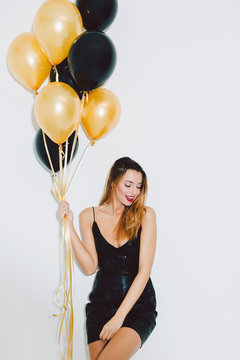 Woman holding balloons in a New Year party celebration.