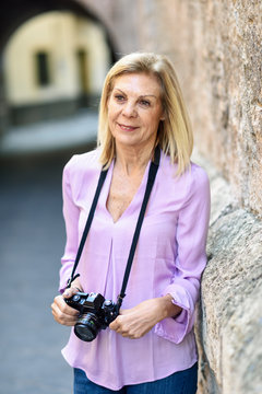 Mature woman with a SLR camera in the city