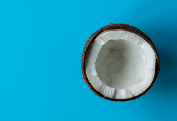 Half coconut on a blue background. Copy space