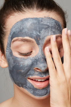 Woman aplying clay mask
