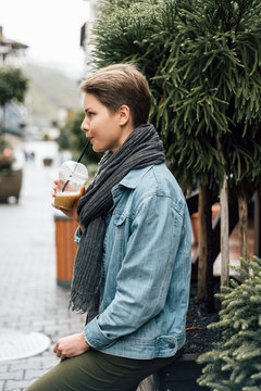 Young woman enjoying drink near plants