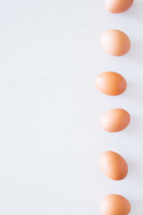 row of brown eggs on white background