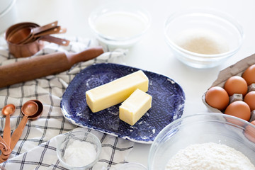 sticks of butter on ceramic dish, baking accessories and ingredients 