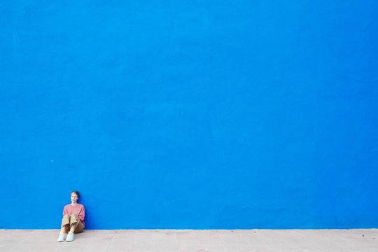 View of woman against bright blue wall