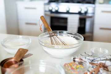Fototapeta na wymiar woman whisking flour in kitchen
