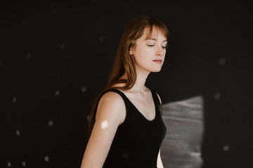 Portrait of young woman on black background